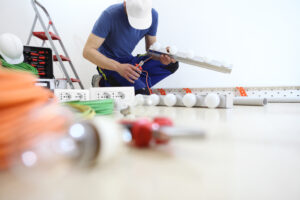 electrician at work with nippers in hand cut the electric cable, install lamps at home, electric circuits, electrical wiring